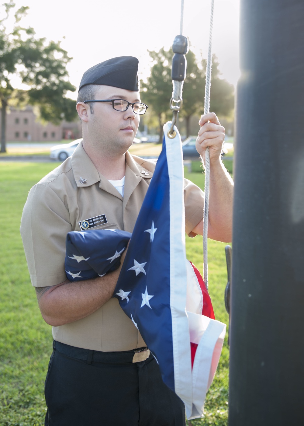 171003-N-LI612-018 KINGS BAY, Ga. (Oct. 3, 2017) Yeoman Submarine 2nd Class Ethan Faircloth raises the flag to half-mast during morning colors on Naval Submarine Base Kings Bay. NSBKB is the east coast home to the Ohio-class submarines. (U.S. Navy photo b