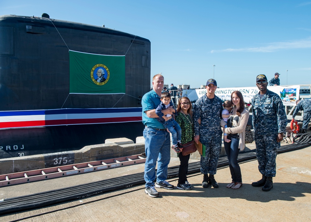 HM1 Michael Couch poses with family and chief after recieveing submarine warfare device
