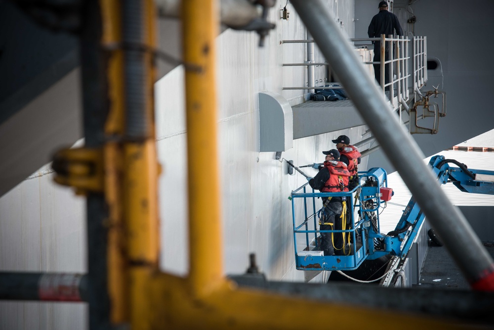 Sailors paint the ship.