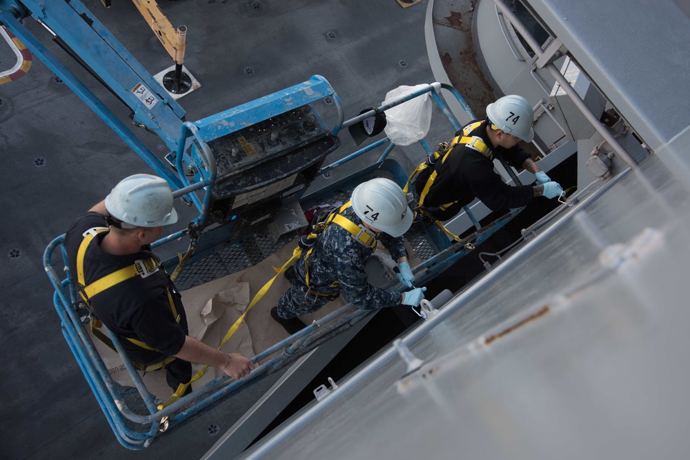 Sailors paint the ship.