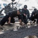 Sailors install a deck plate.