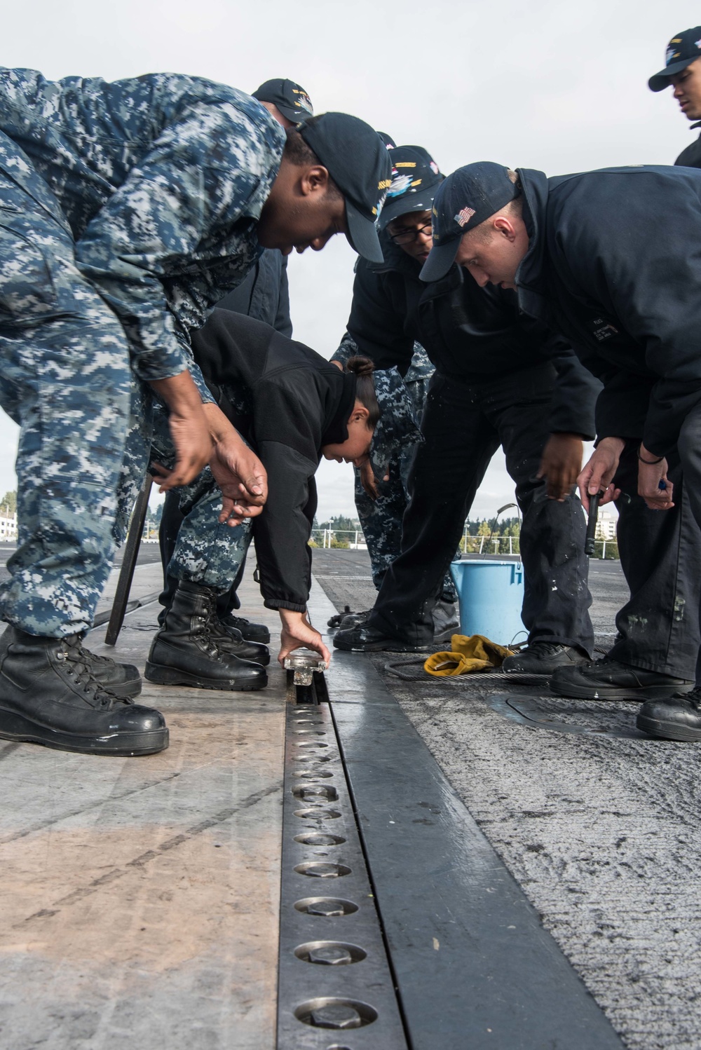 Sailors install a deck plate.