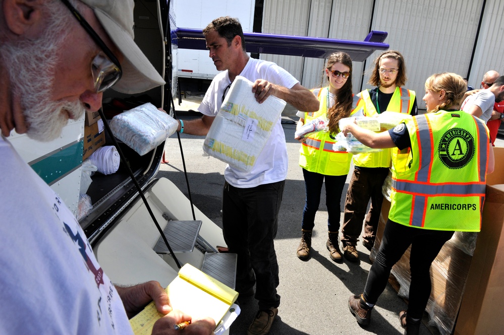 Members of the federal government response prepare pallets of infant care items for distribution to Puerto Rican families in need