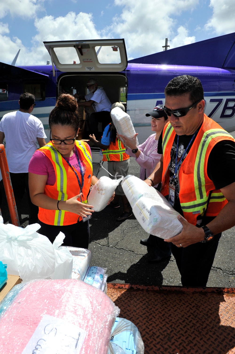 Secretary of the Puerto Rico Department of Family and responders unload infant care goods for distribution to families in need