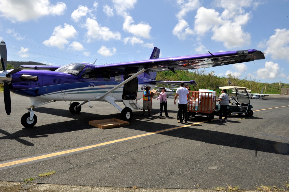 Secretary of the Puerto Rico Department of Family and responders unload infant care goods for distribution to families in need