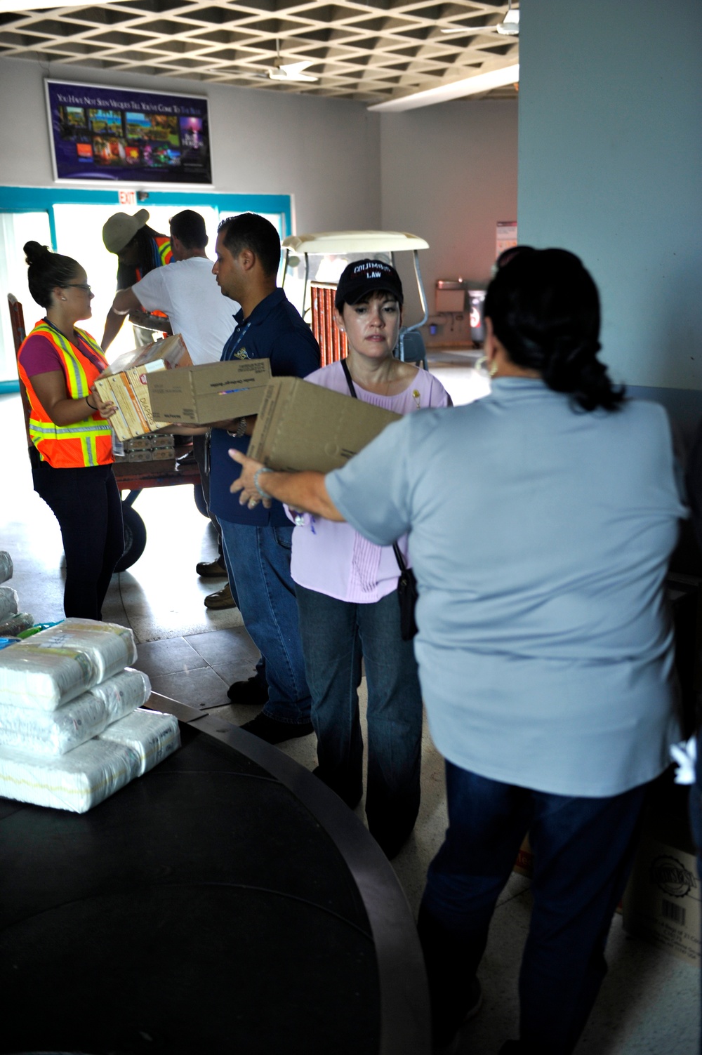 Secretary of the Puerto Rico Department of Family and responders unload infant care goods for distribution to families in need