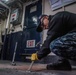 Sailor removes non-skid from the deck.