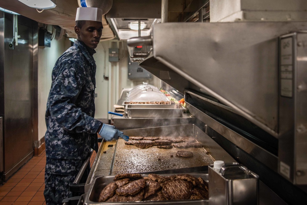 Sailor prepares hamburgers.