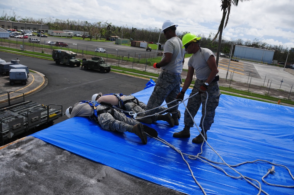 156th Civil Engineering Squadron repair roof with FEMA blue sheets