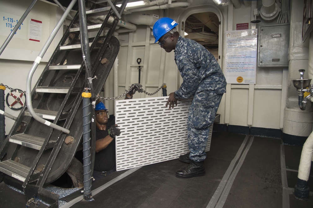 Culinary Specialist 3rd Class James Stormier of Farrell, Pa., left, and Culinary Specialist Seaman Soboa Amoussi, a Lome, Togo native, move deck grates from the first deck to the second deck of the aircraft carrier USS Dwight D. Eisenhower (CVN 69)(Ike).