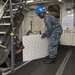 Culinary Specialist 3rd Class James Stormier of Farrell, Pa., left, and Culinary Specialist Seaman Soboa Amoussi, a Lome, Togo native, move deck grates from the first deck to the second deck of the aircraft carrier USS Dwight D. Eisenhower (CVN 69)(Ike).