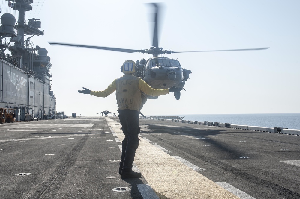 USS America Sailor signals helicopter