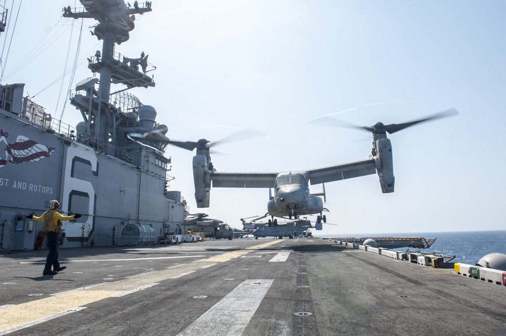 USS America Sailor signals MV-22 Osprey lift off