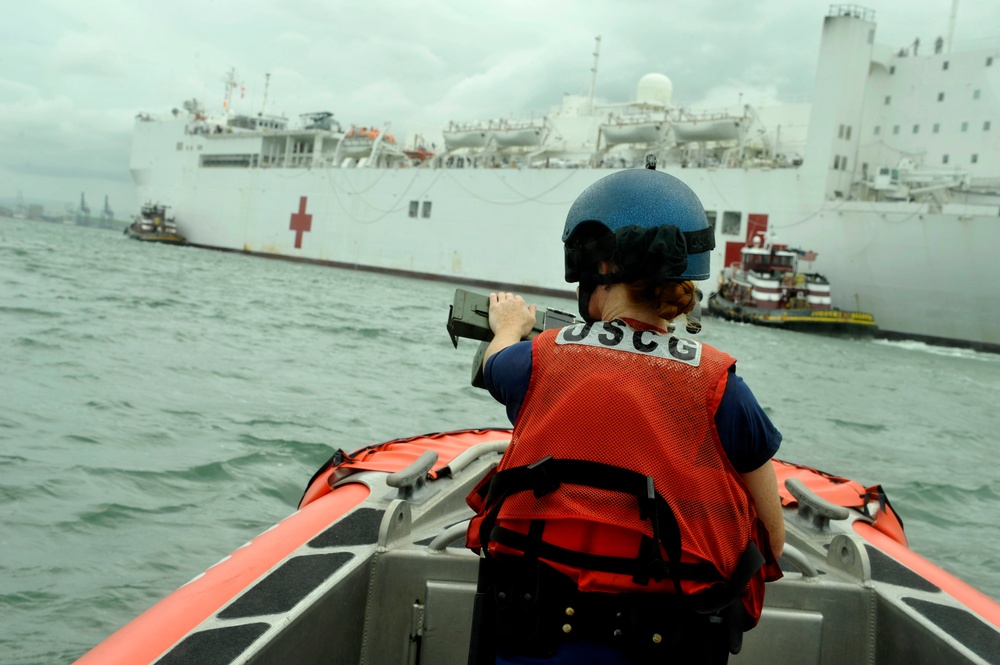 Coast Guard crewmembers escort the USNS Comfort into San Juan, Puerto Rico