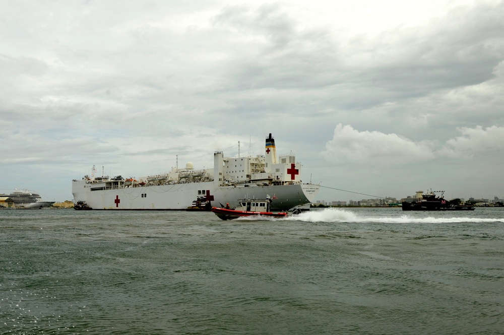 Coast Guard crewmembers escort the USNS Comfort into San Juan, Puerto Rico