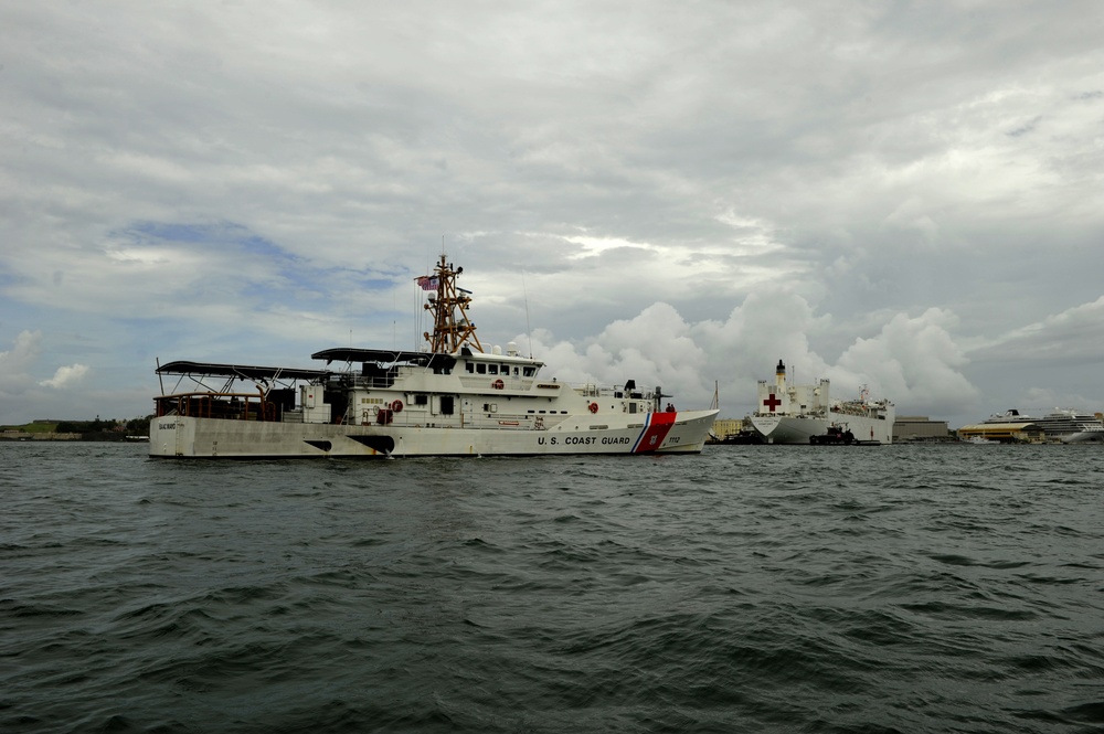 Coast Guard crewmembers escort the USNS Comfort into San Juan, Puerto Rico