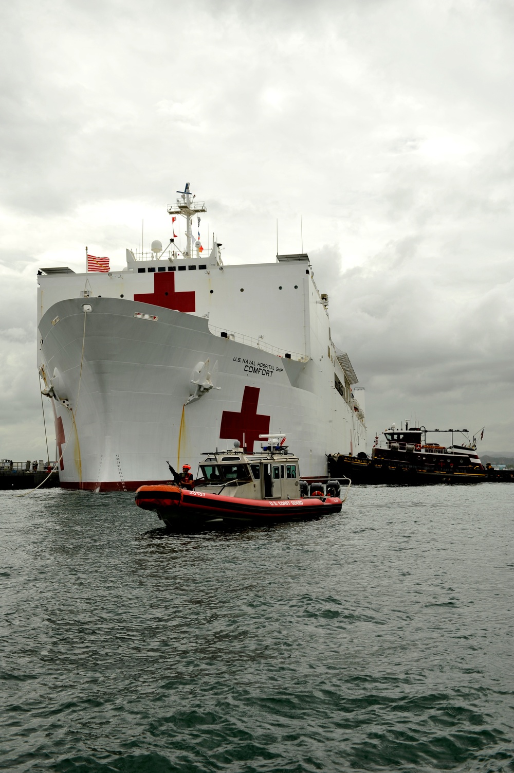 Coast Guard crewmembers escort the USNS Comfort into San Juan, Puerto Rico