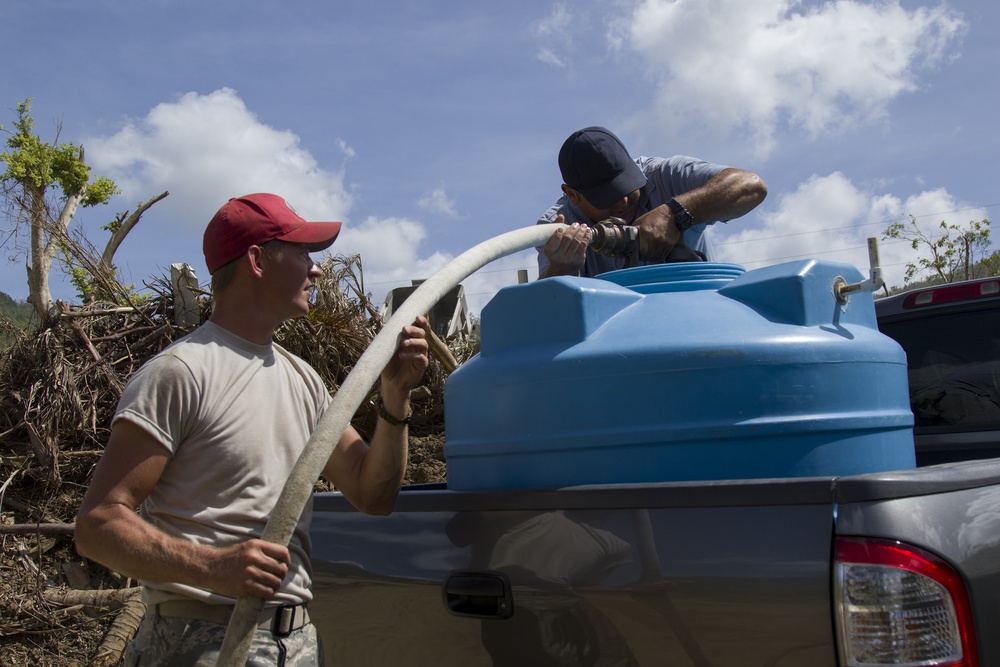 Airman Helps Resident Fill Water Tank