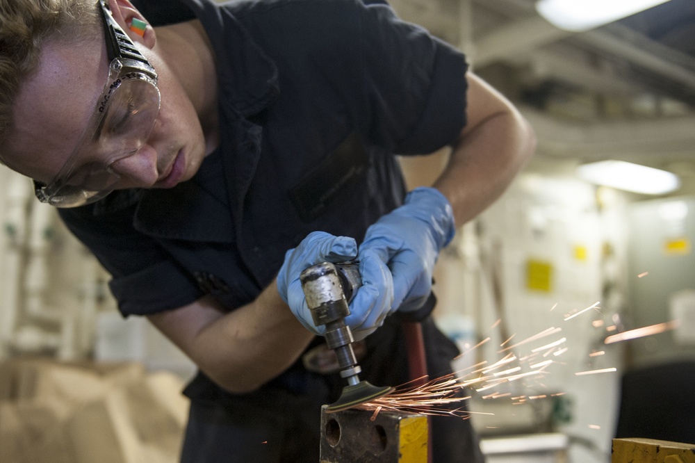 USS America Sailors sand down forklift