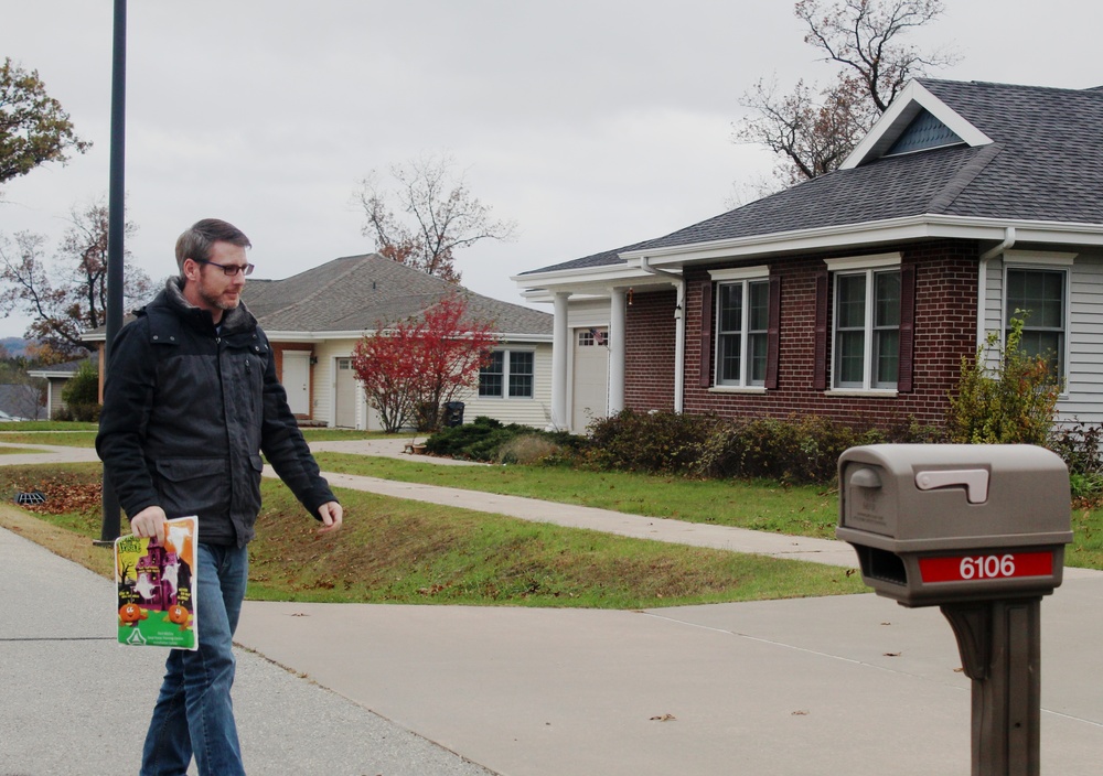 Safety personnel deliver Halloween treat bags to Fort McCoy families