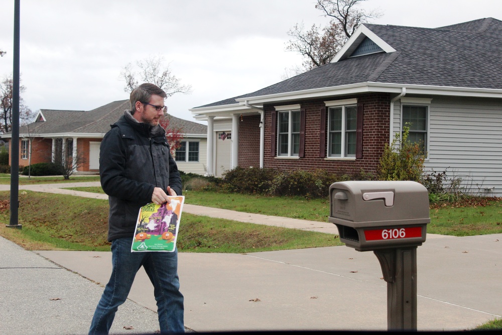 Safety personnel deliver Halloween treat bags to Fort McCoy families