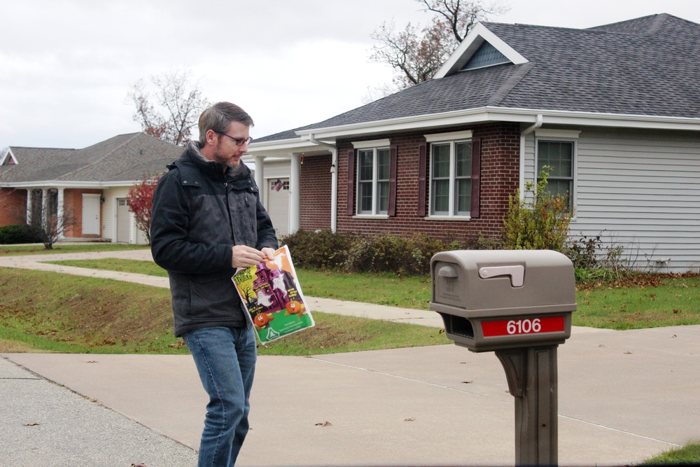 Safety personnel deliver Halloween treat bags to Fort McCoy families