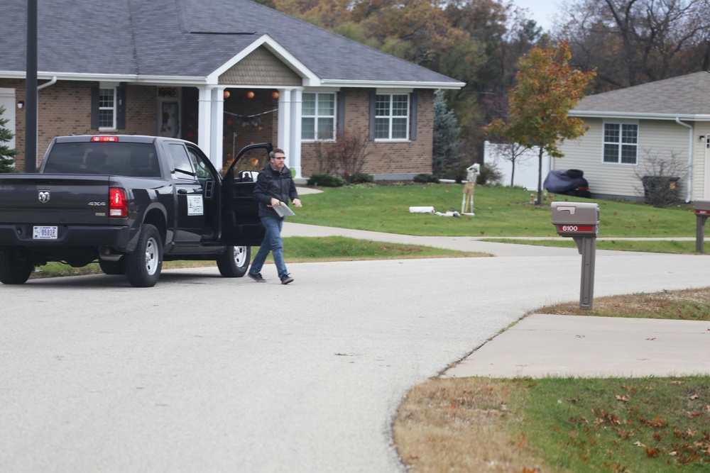 Safety personnel deliver Halloween treat bags to Fort McCoy families