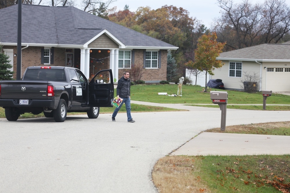 Safety personnel deliver Halloween treat bags to Fort McCoy families