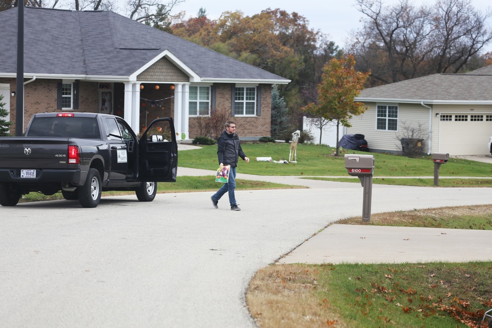 Safety personnel deliver Halloween treat bags to Fort McCoy families