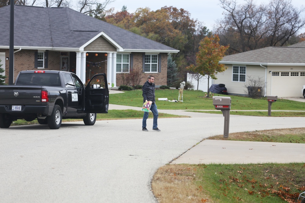 Safety personnel deliver Halloween treat bags to Fort McCoy families