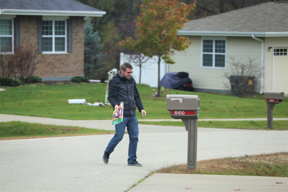 Safety personnel deliver Halloween treat bags to Fort McCoy families