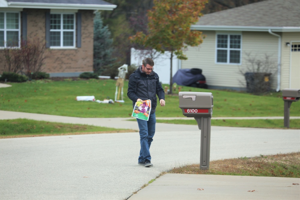 Safety personnel deliver Halloween treat bags to Fort McCoy families