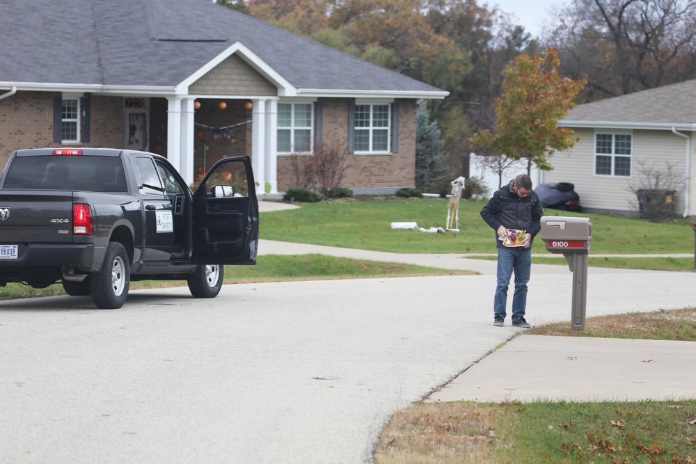 Safety personnel deliver Halloween treat bags to Fort McCoy families