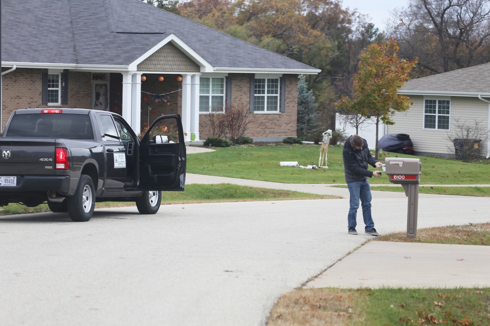 Safety personnel deliver Halloween treat bags to Fort McCoy families