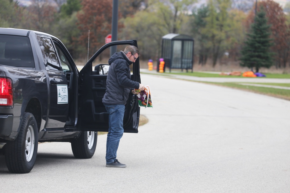 Safety personnel deliver Halloween treat bags to Fort McCoy families