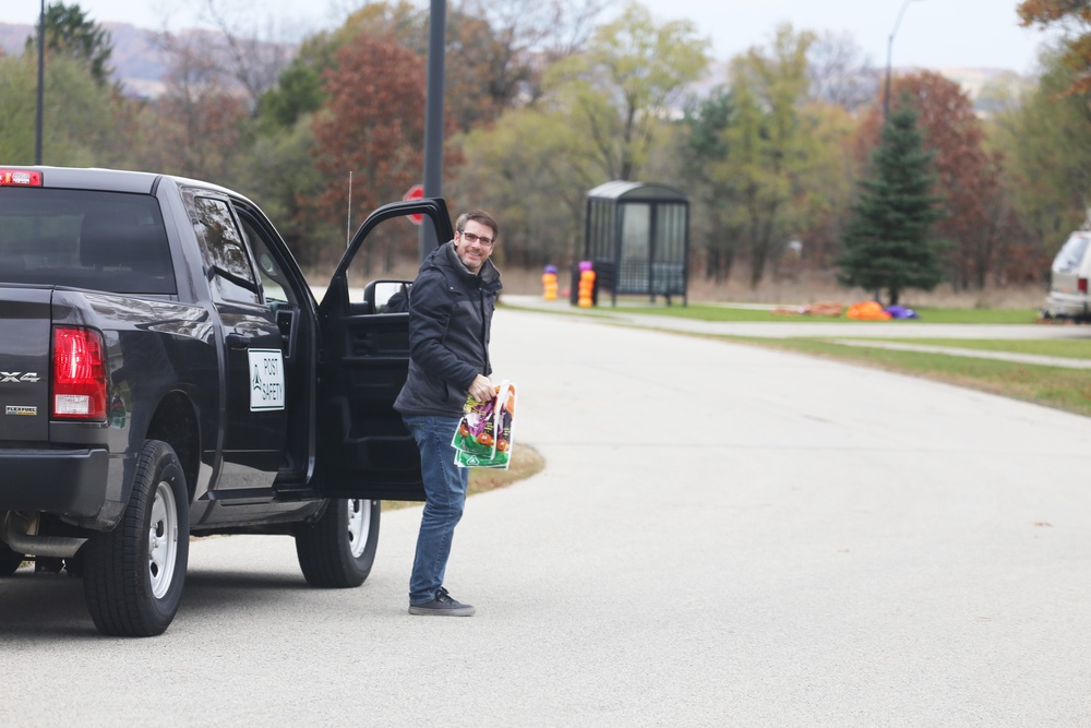 Safety personnel deliver Halloween treat bags to Fort McCoy families