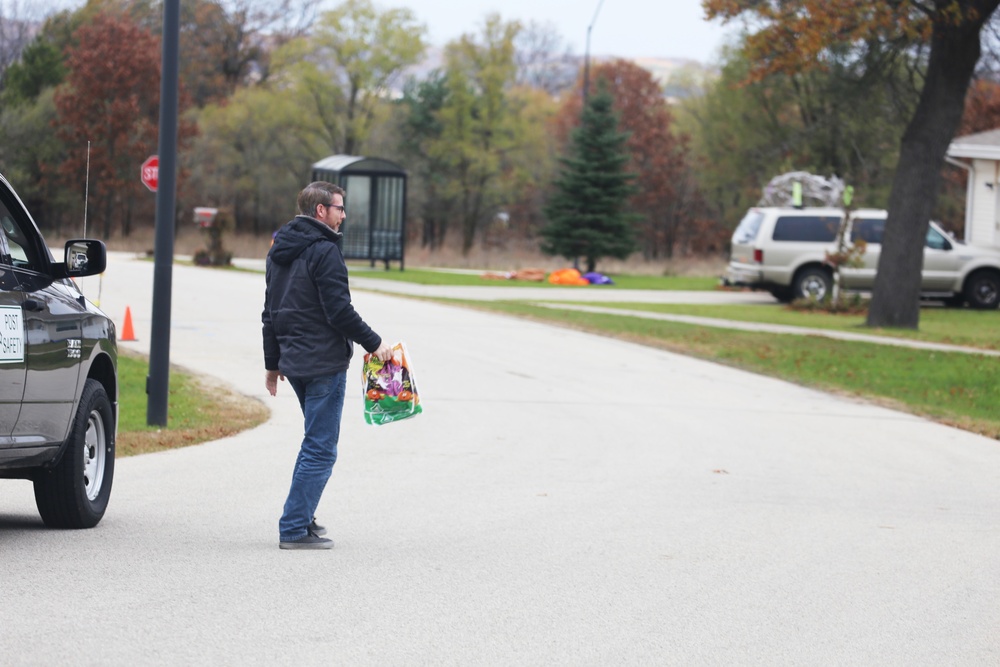 Safety personnel deliver Halloween treat bags to Fort McCoy families