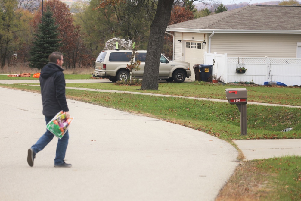 Safety personnel deliver Halloween treat bags to Fort McCoy families