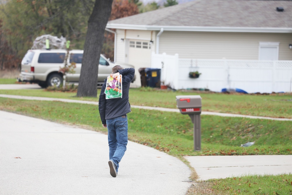 Safety personnel deliver Halloween treat bags to Fort McCoy families