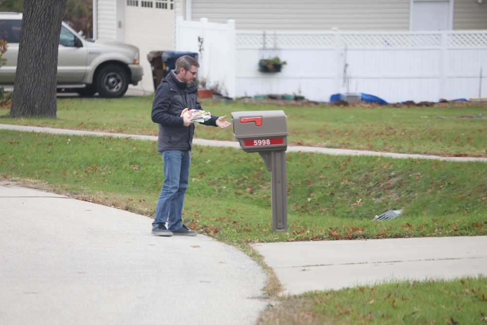 Safety personnel deliver Halloween treat bags to Fort McCoy families