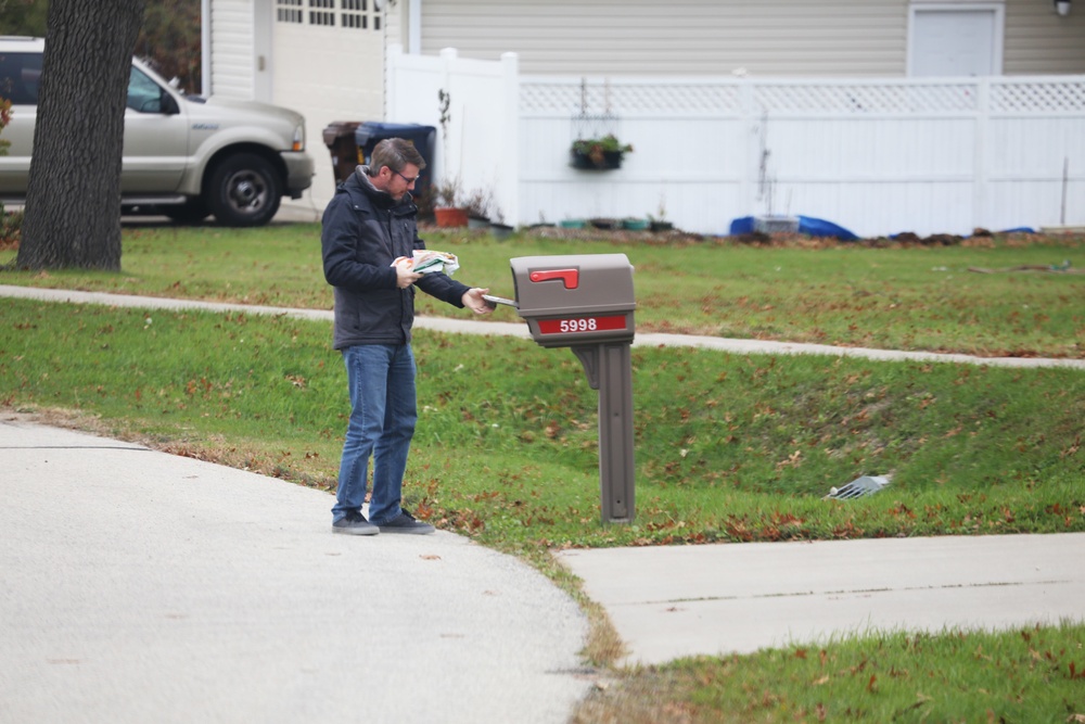 Safety personnel deliver Halloween treat bags to Fort McCoy families