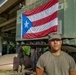 Soldier Poses in Front of Puerto Rican Flag