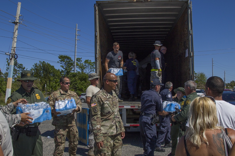 Relief Effort Personnel Hand Out Water