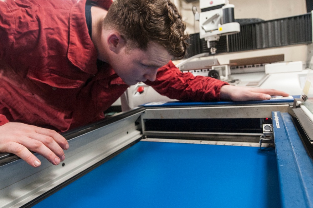 USS America Sailor calibrates engraving machine