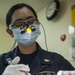 USS America Sailor performs tooth filling
