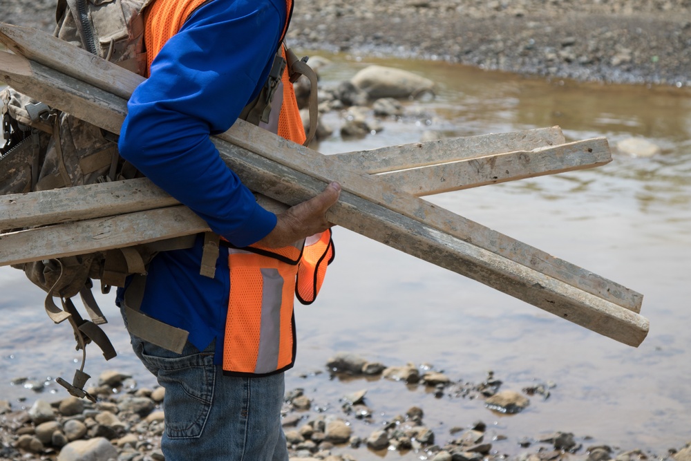 Worker Carries Surveying Stakes during USACE Emergency Levee Project, Puerto Rico