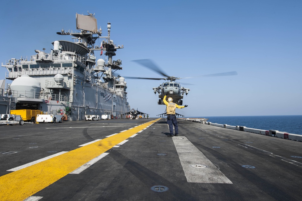 USS America Sailor signals aircraft to lift off