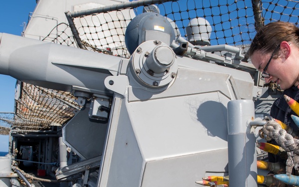 Sailor loads Mark 38 25 mm machine gun