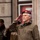 NATO Military Committee visit to Sarajevo A senior military officer in a maroon/burgundy beret with gold insignia and stars is rendering a salute. He wears an olive/tan tactical jacket with a name tape and camouflage trousers, suggesting a formal military ceremony or review. Additional uniformed personnel are visible in the blurred background.