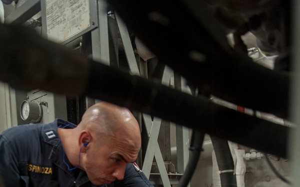 USS America Sailor inspects engine space for water leaks